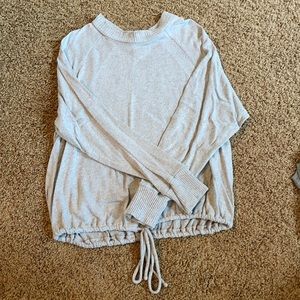 Woman’s grey sweater with drawstring bottom